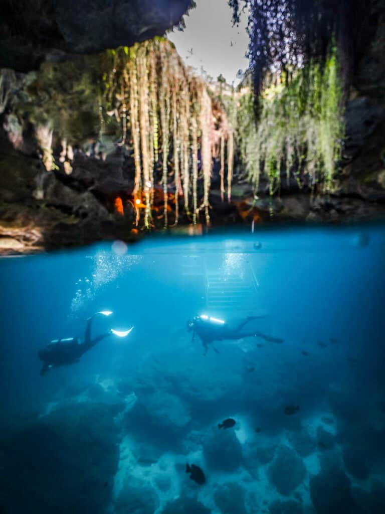 people scuba diving in cave