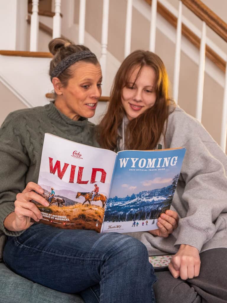 Mon and daughter reading a magazine about Wyoming.