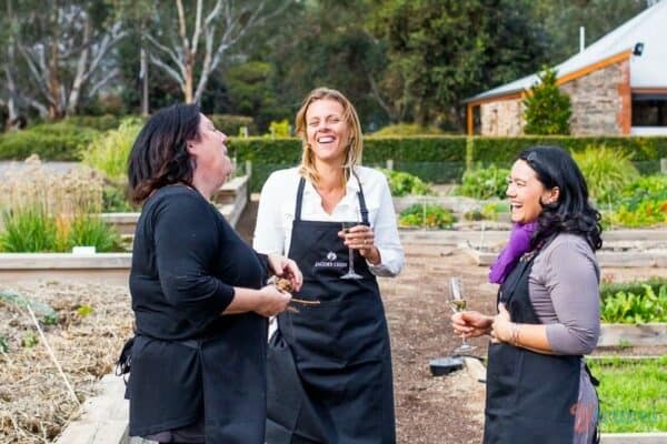group of women drinking wine and laughing in the vineyards