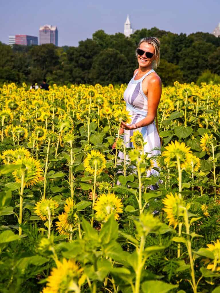 woman standing in sunflower field in dorothea dix park raleigh