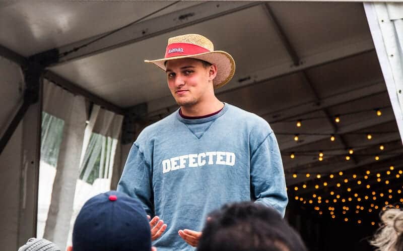 a harvard student tour guide wearing a hat