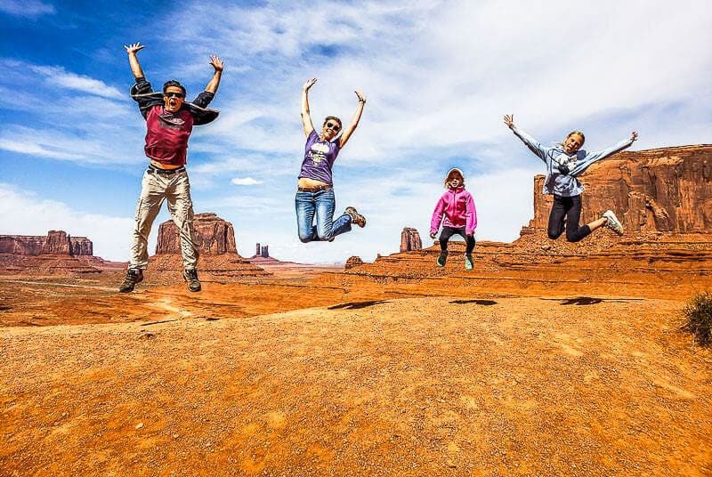 people jumping in the air at monument valley