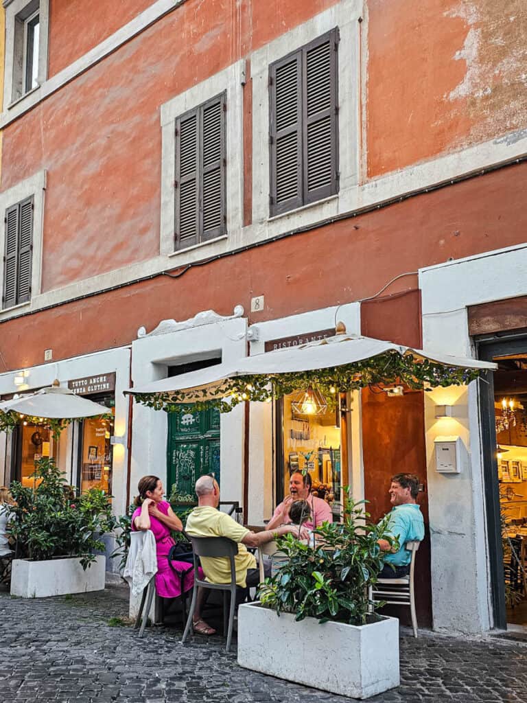 people sitting outside restaurant in trastevere