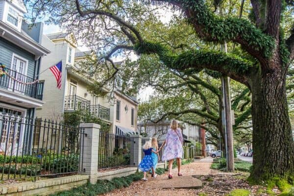 woman and child walking through garden district nola
