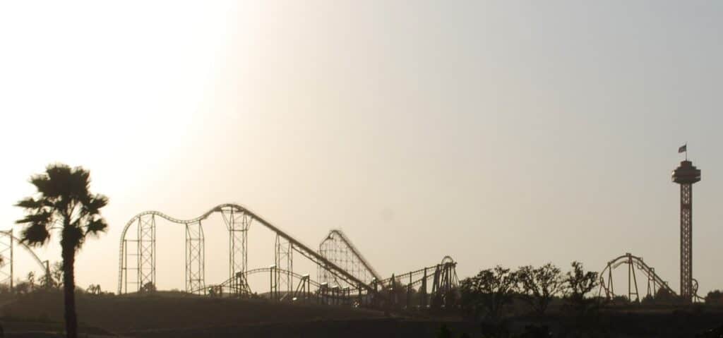 Six Flags - Magic Mountain amusement park in California. Roller-coasters and tower silhouetted by a hazy winter sun.