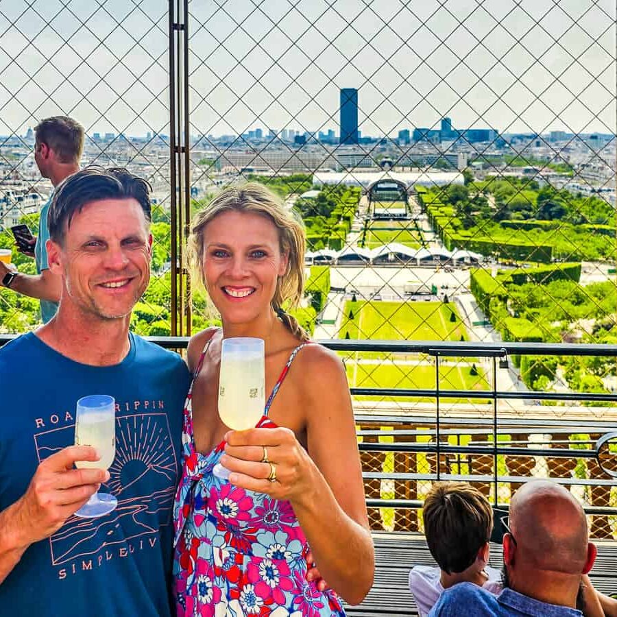 Man and lady drinking a glass of wine overlooking the cith view from Eiffel Tower